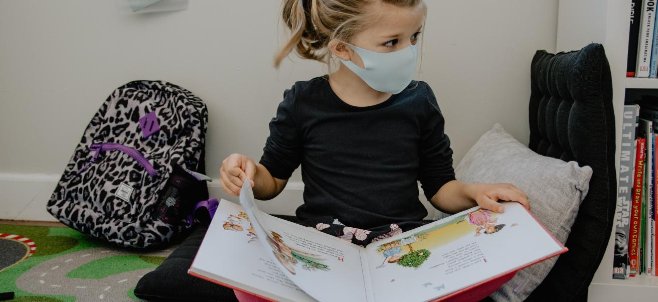 Kind liest Buch während der Coronakrise